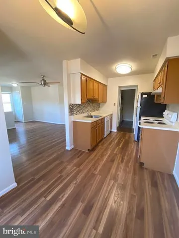 a kitchen view with wooden floor and stainless steel appliances