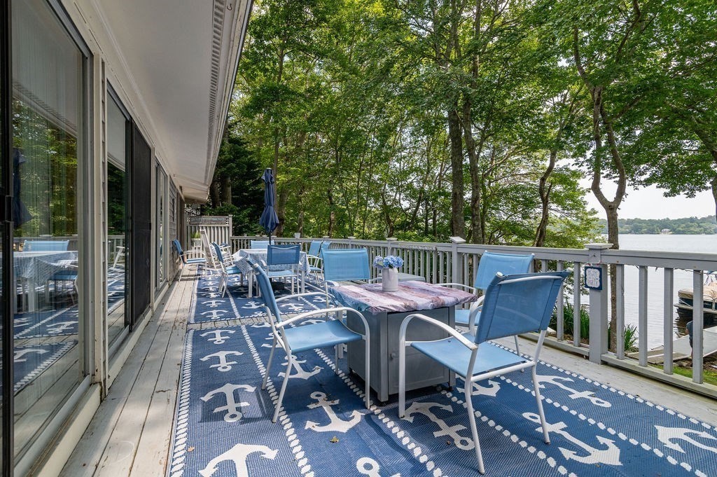 233 Hooppole Road Mashpee, MA 02649 - Photo 25 of 41 a view of a patio with table and chairs and wooden floor