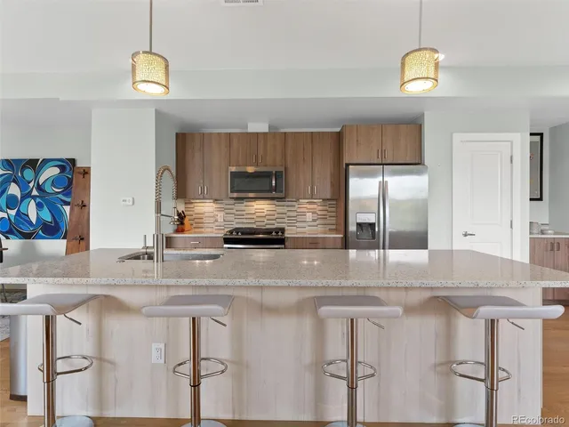 a kitchen with kitchen island granite countertop a stove cabinets and refrigerator