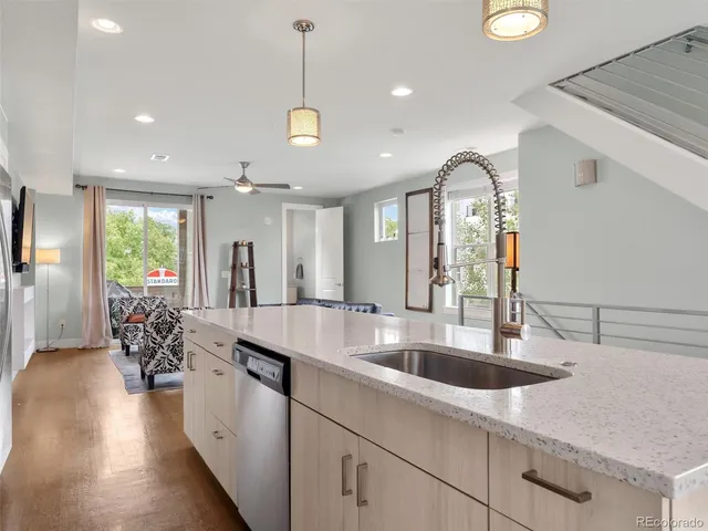 a large kitchen with kitchen island a large counter top space a sink stainless steel appliances and windows