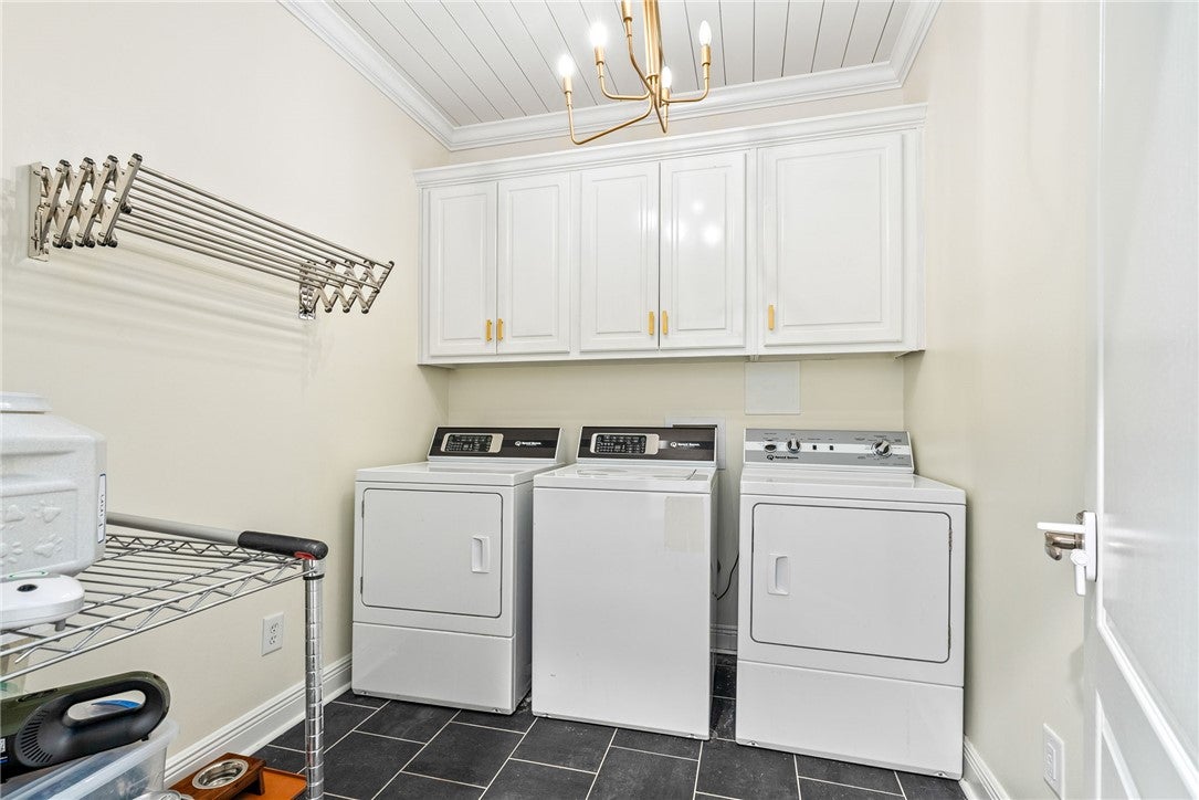 1657 Abby Road Auburn, AL 36830 - Photo 35 of 39 This laundry room features ample storage, practical appliances, and a convenient drying rack.