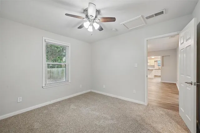 an empty room with windows and fan