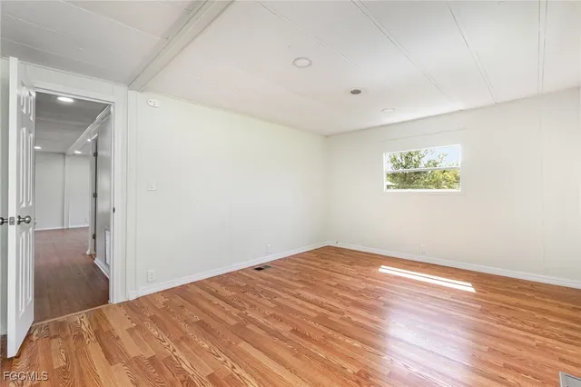 a view of a big room with wooden floor and windows