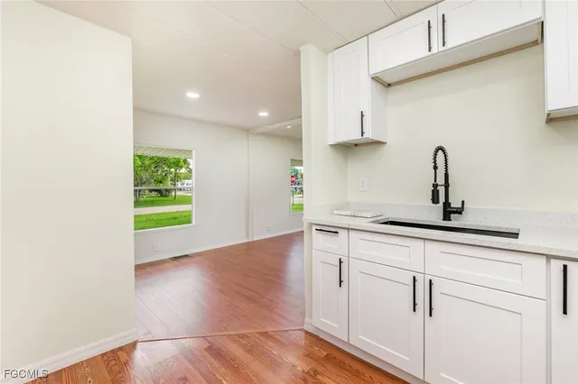 a kitchen with a sink cabinets and wooden floor