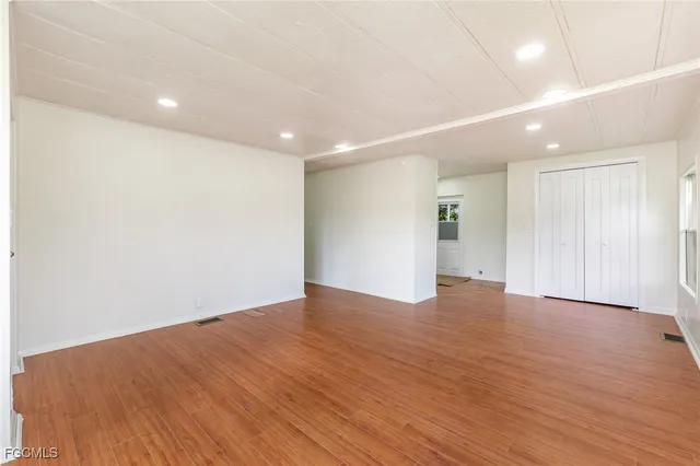 a view of an empty room with wooden floor