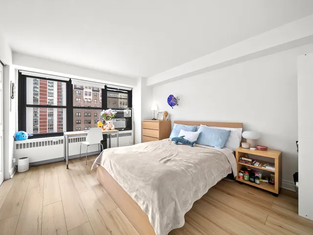 a bedroom with a bed and a large window