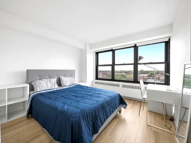 a spacious bedroom with a large bed and a large window