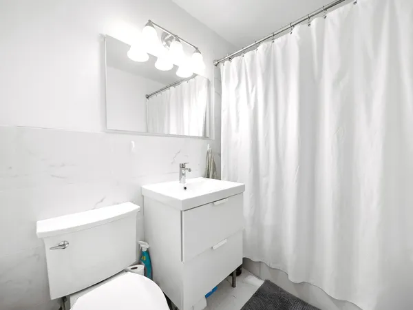 a bathroom with a sink a toilet and shower curtain