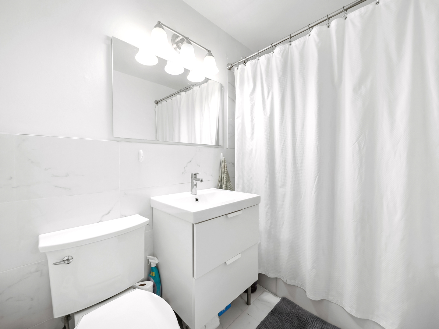 6118 North Sheridan Road, Unit 1008 Chicago, IL 60660 - Photo 10 of 19 a bathroom with a sink a toilet and shower curtain