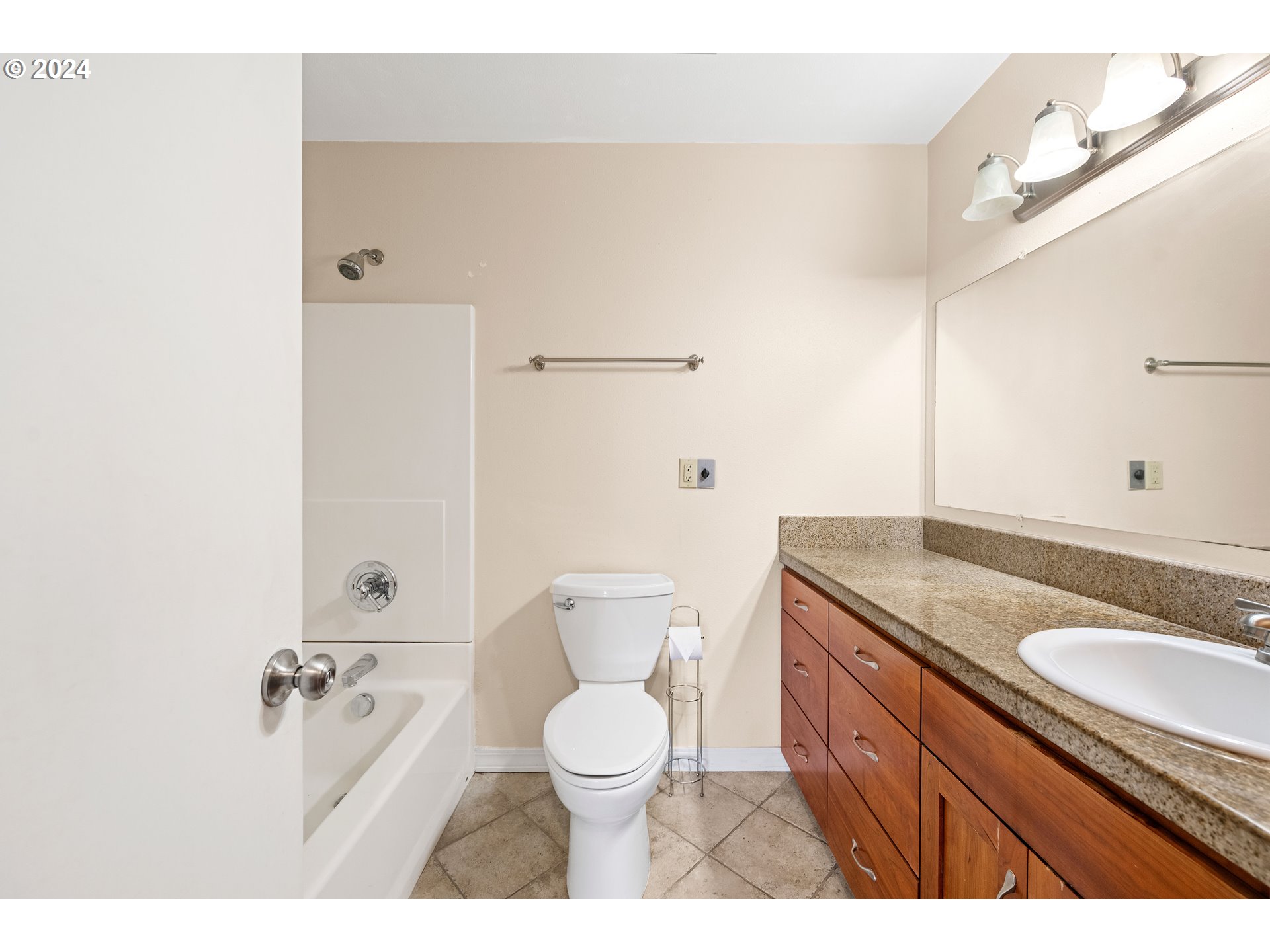 91897 Ridge Road Warrenton, OR 97146 - Photo 17 of 24 a bathroom with a granite countertop sink toilet a mirror and bathtub
