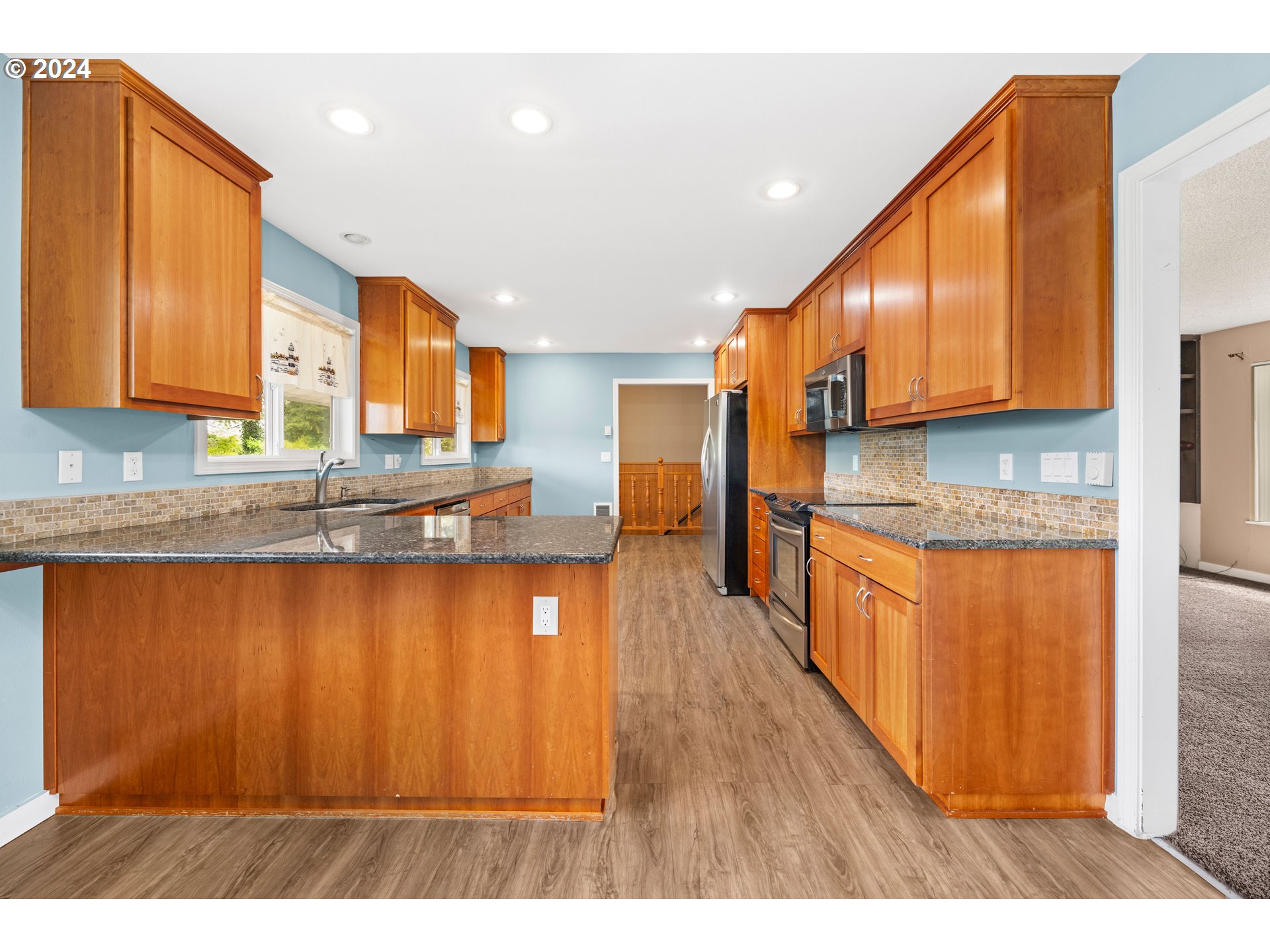 91897 Ridge Road Warrenton, OR 97146 - Photo 7 of 24 a kitchen with stainless steel appliances granite countertop a stove a sink dishwasher and a refrigerator with wooden floor