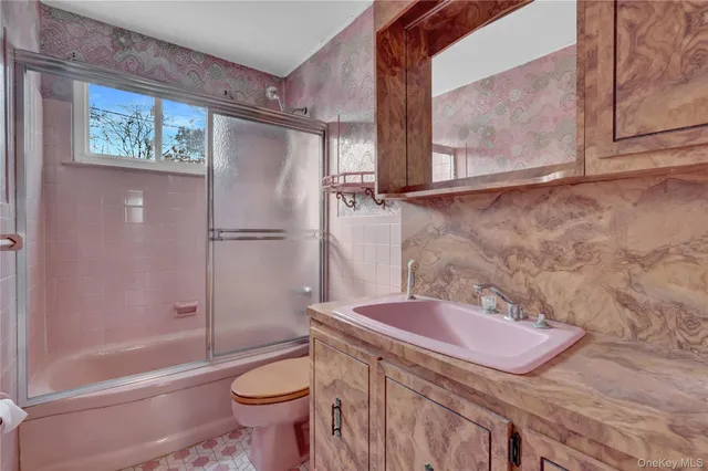 a bathroom with a sink a toilet and shower