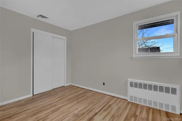 a view of a room with wooden floor and window