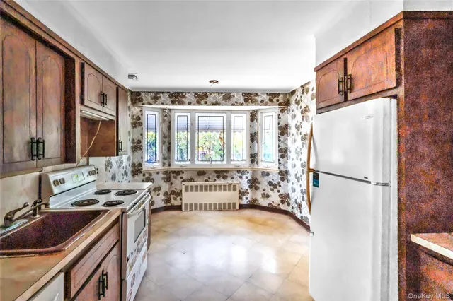 a kitchen with stainless steel appliances a refrigerator sink and white cabinets