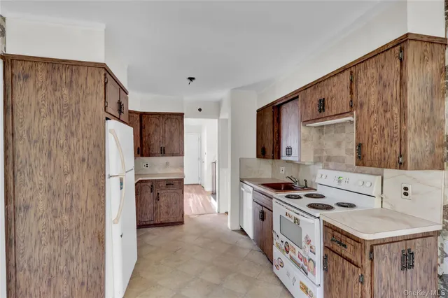 a kitchen with stainless steel appliances a stove a sink and a refrigerator