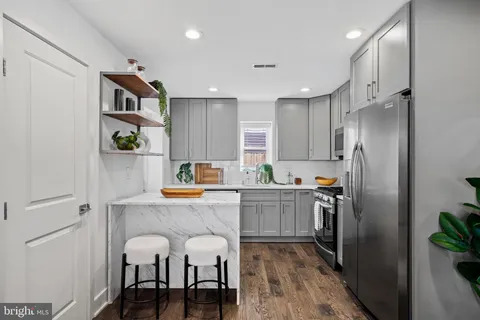 a kitchen with stainless steel appliances granite countertop a refrigerator and a stove top oven