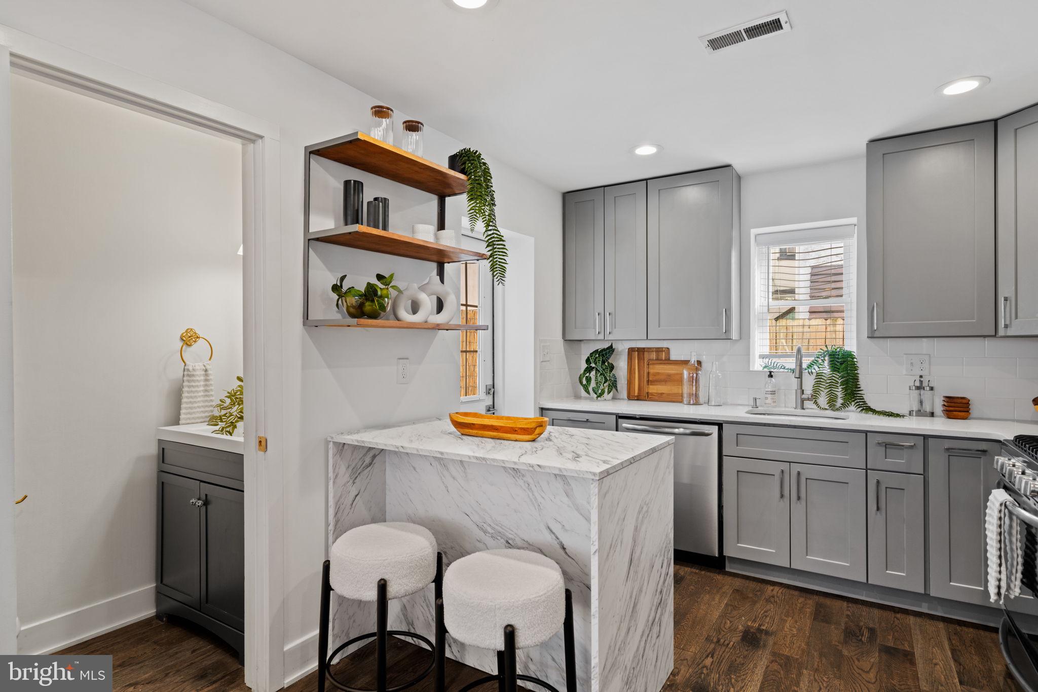 1629 South Camac Street Philadelphia, PA 19148 - Photo 13 of 34 a kitchen with stainless steel appliances granite countertop a sink cabinets and window