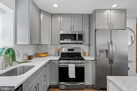 a kitchen with stainless steel appliances granite countertop a stove a refrigerator and a sink