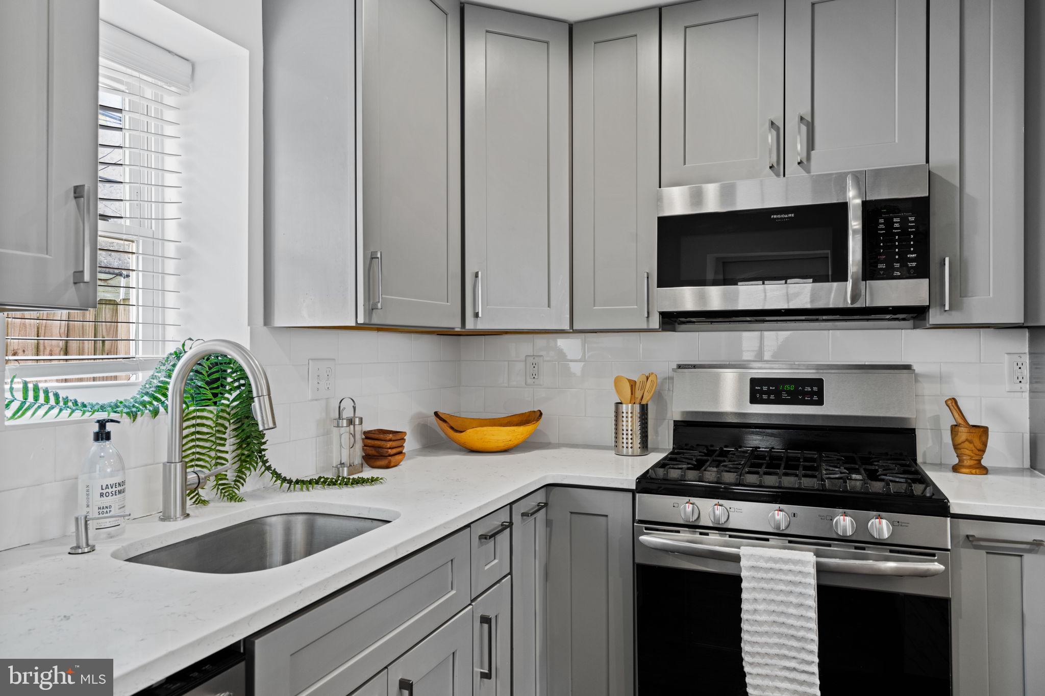 1629 South Camac Street Philadelphia, PA 19148 - Photo 18 of 34 a kitchen with granite countertop a sink a stove and cabinets