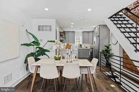 a view of a dining room with furniture wooden floor and a potted plant