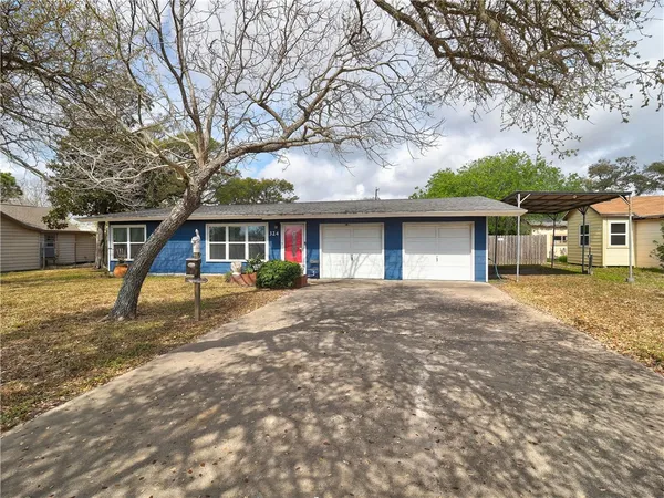 a view of a house with a yard and large tree