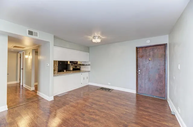 a view of a livingroom with wooden floor and a ceiling fan