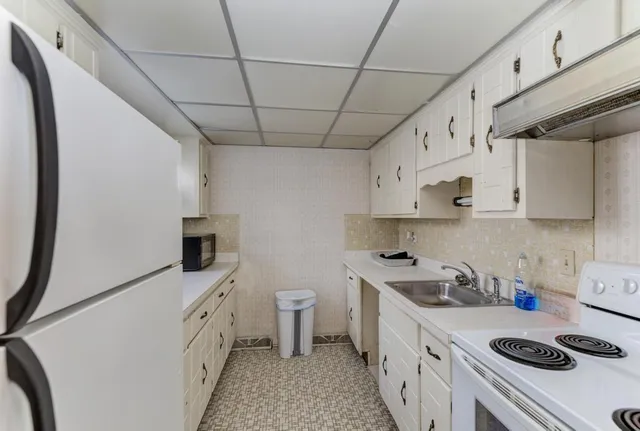 a kitchen with granite countertop a sink a stove and wooden cabinets