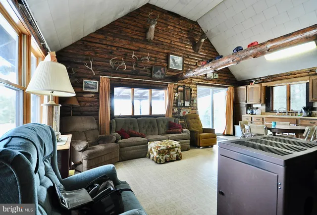 a living room with furniture a large window and a fireplace