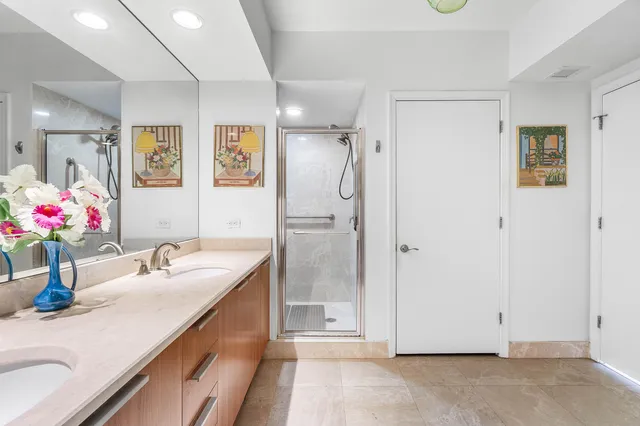 a bathroom with a granite countertop shower sink and mirror