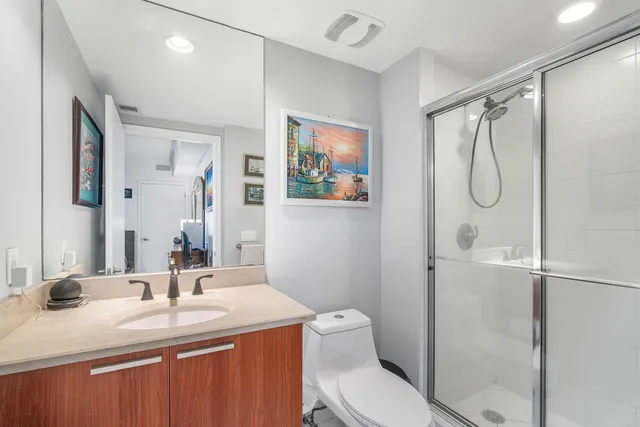 a bathroom with a granite countertop sink toilet and shower