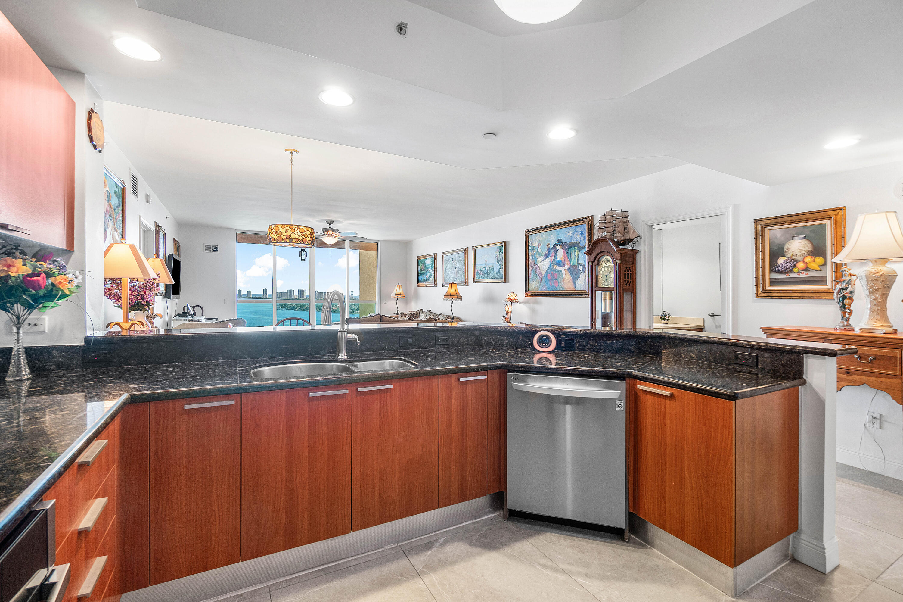 2650 Lake Shore Drive, Unit 1705 Riviera Beach, FL 33404 - Photo 3 of 35 a kitchen with stainless steel appliances granite countertop a sink and wooden cabinets