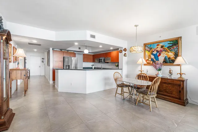 a kitchen with stainless steel appliances kitchen island granite countertop a table and chairs in it