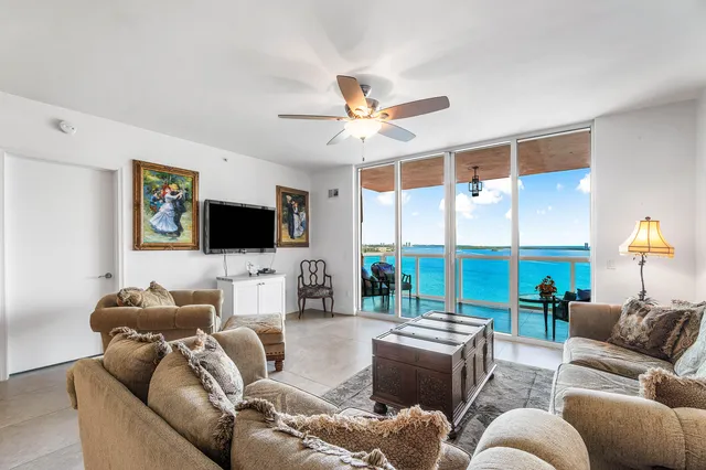 a living room with furniture a flat screen tv and a large window