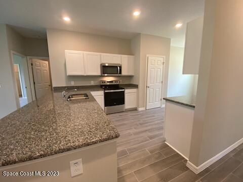 1643 Uniontown Street Southeast Palm Bay, FL 32909 - Photo 3 of 6 a kitchen with stainless steel appliances granite countertop a refrigerator and a sink