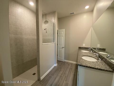 1643 Uniontown Street Southeast Palm Bay, FL 32909 - Photo 5 of 6 a bathroom with a granite countertop sink a mirror and shower