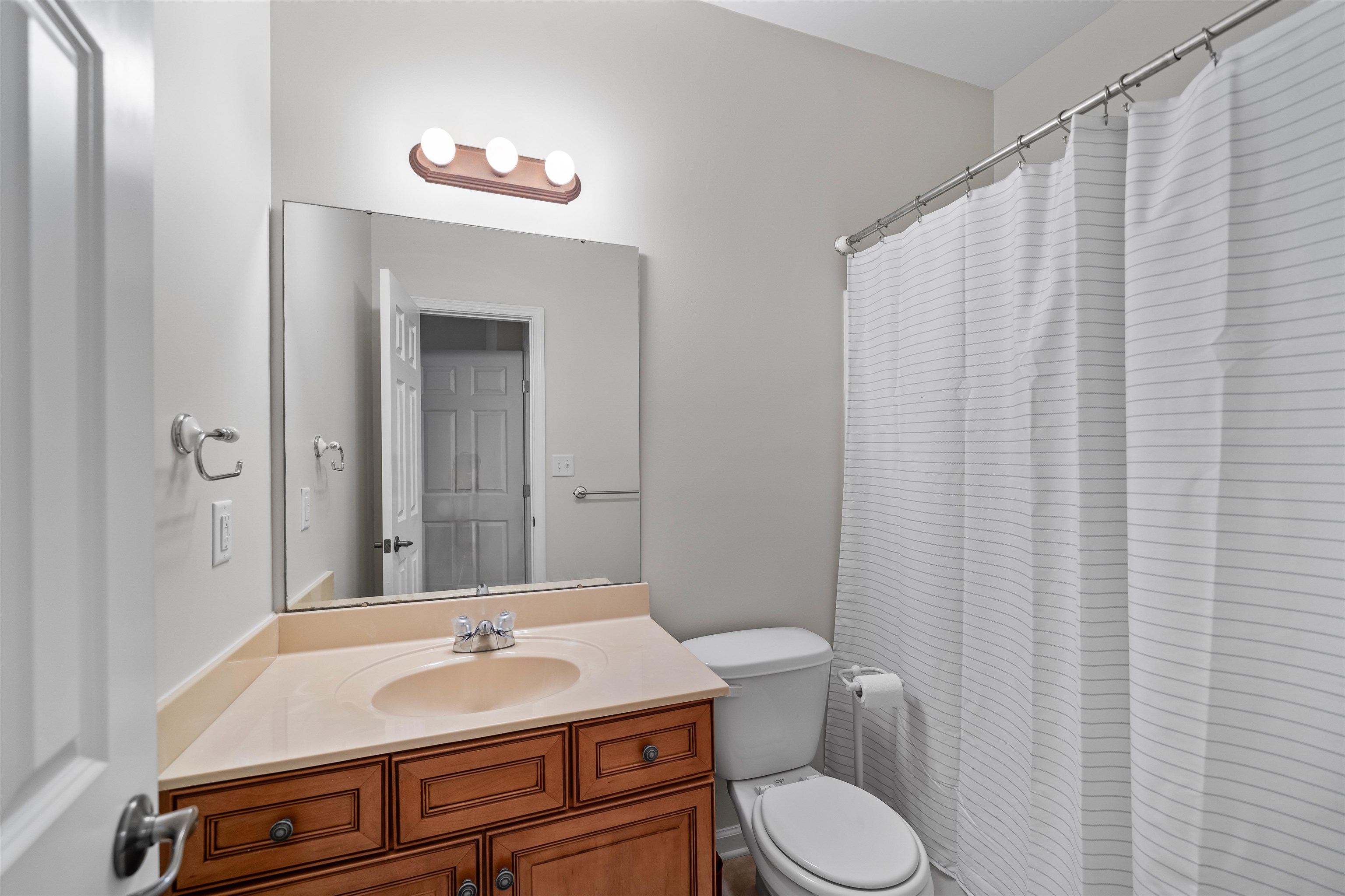 5035 Brian Ridge Road Arlington, TN 38002 - Photo 26 of 40 Bathroom featuring a wood-finish vanity with a light-toned countertop, a built-in sink, and a large wall-mounted mirror