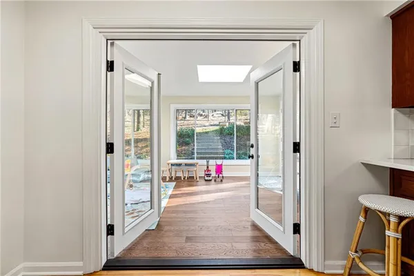 a view of a hallway with wooden floor and living room
