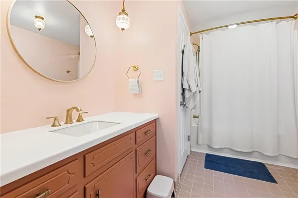 a bathroom with a sink a mirror a vanity and a shower