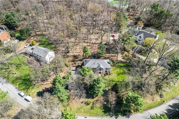 an aerial view of residential house with outdoor space and trees all around