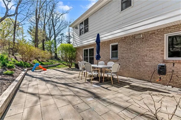 a view of backyard with a table and chairs and potted plants