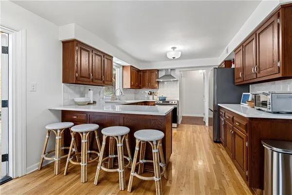 a kitchen with granite countertop wooden floors cabinets a sink and appliances
