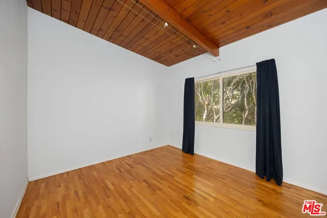 a view of a big room with wooden floor and windows