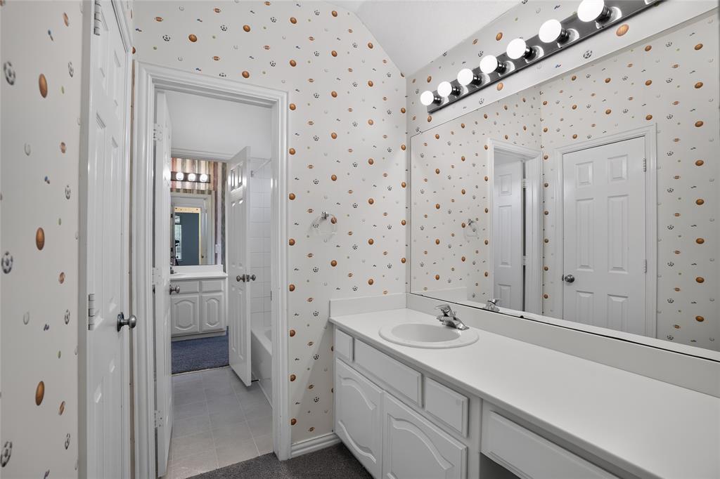 111 Ripplewood Coppell, TX 75019 - Photo 24 of 34 Bathroom vanity featuring an integrated sink, polished chrome faucet, and expansive wall-mounted mirror
