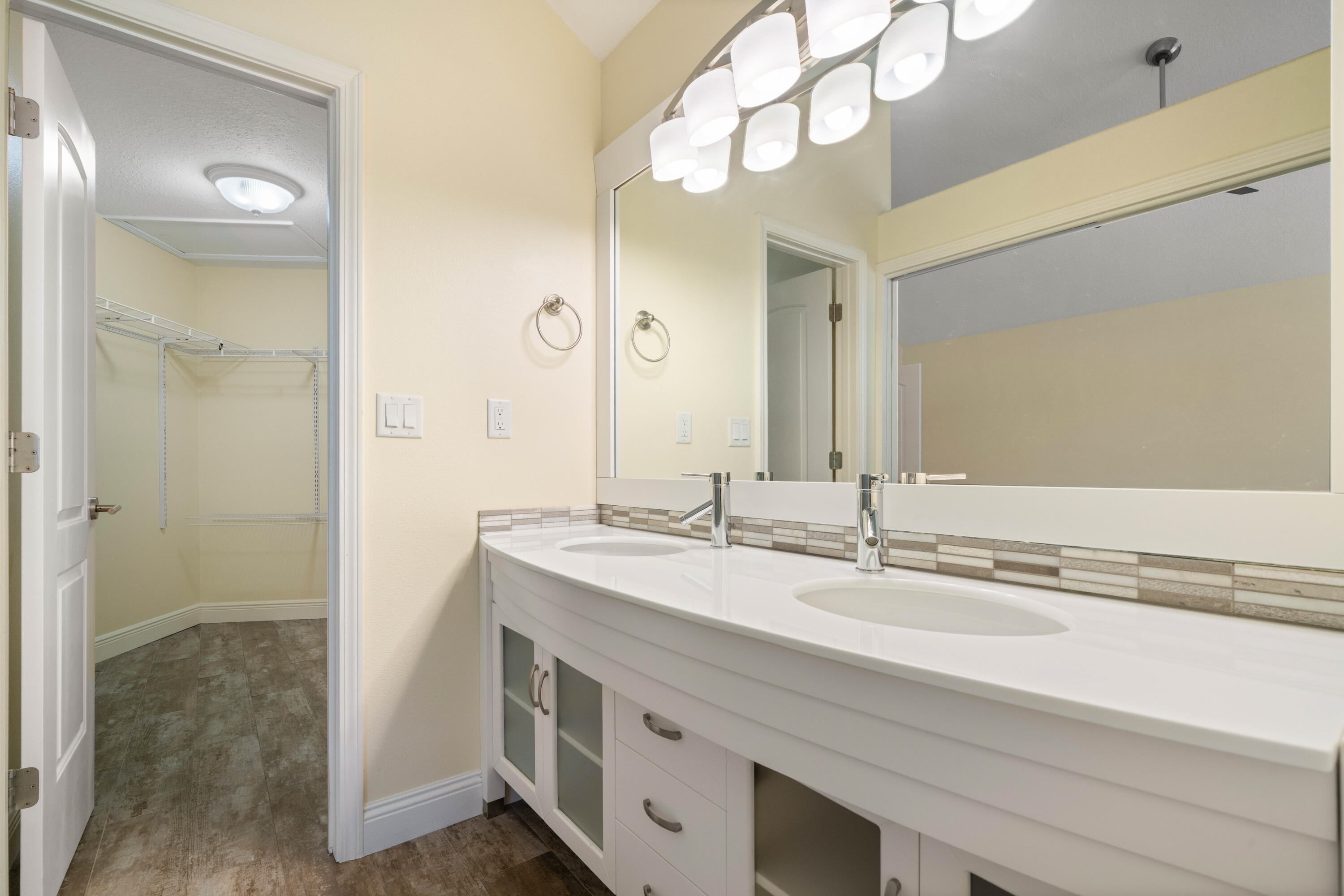235 Pelican Place, Unit 3 Destin, FL 32541 - Photo 16 of 32 a bathroom with a sink a mirror and a shower