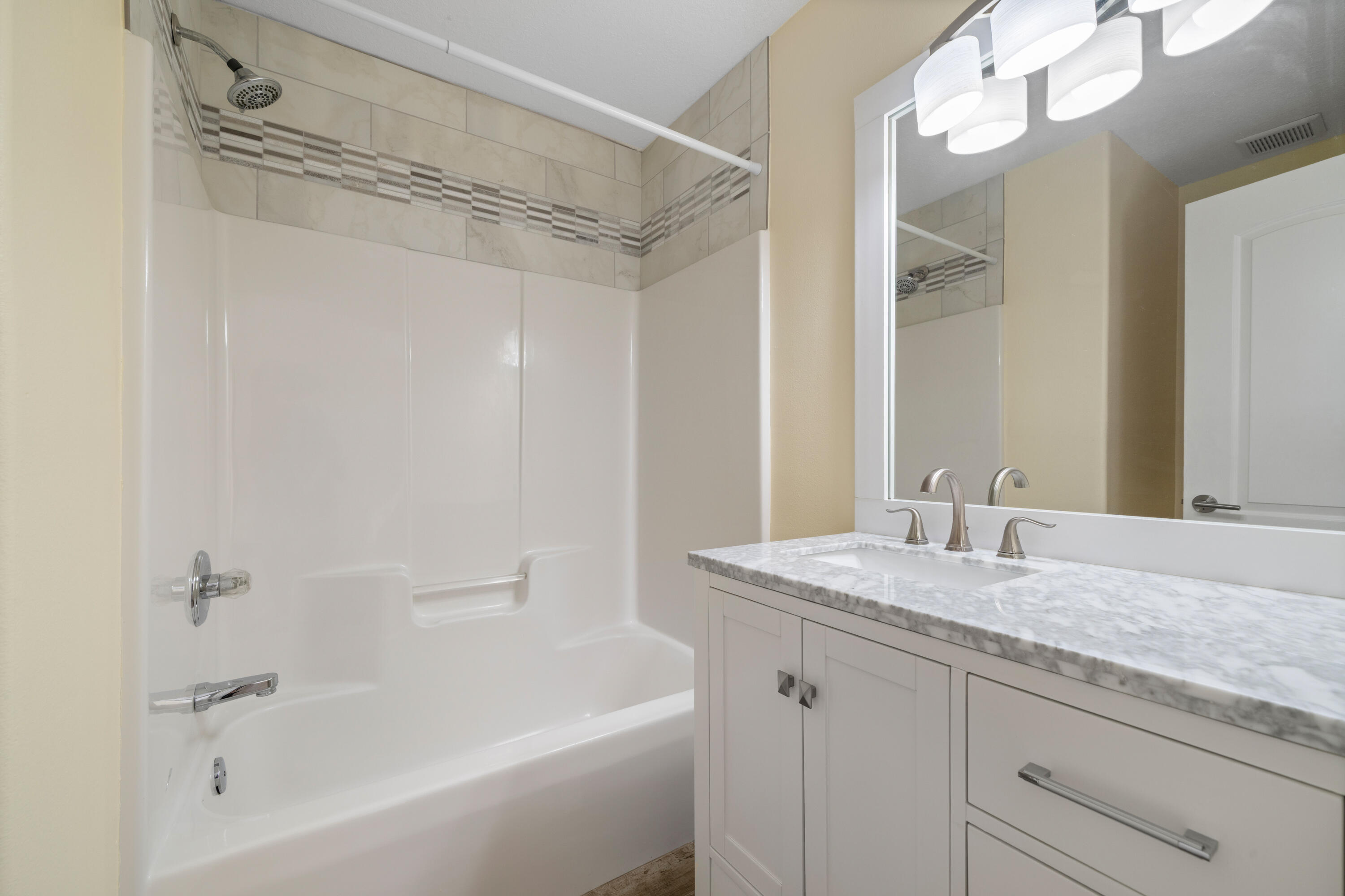 235 Pelican Place, Unit 3 Destin, FL 32541 - Photo 22 of 32 a bathroom with a granite countertop sink mirror and a bathtub