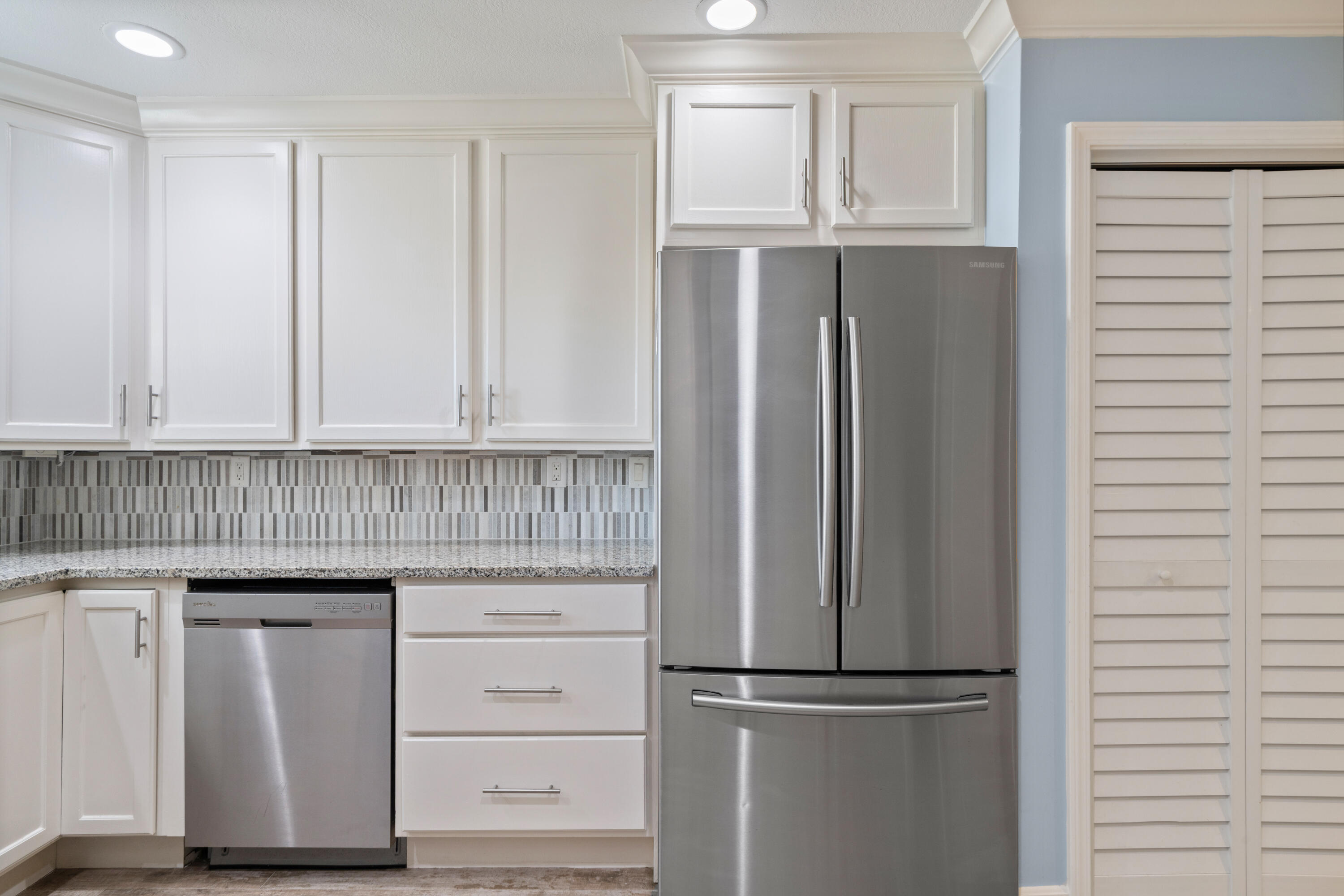 235 Pelican Place, Unit 3 Destin, FL 32541 - Photo 3 of 32 a kitchen with white cabinets and a refrigerator