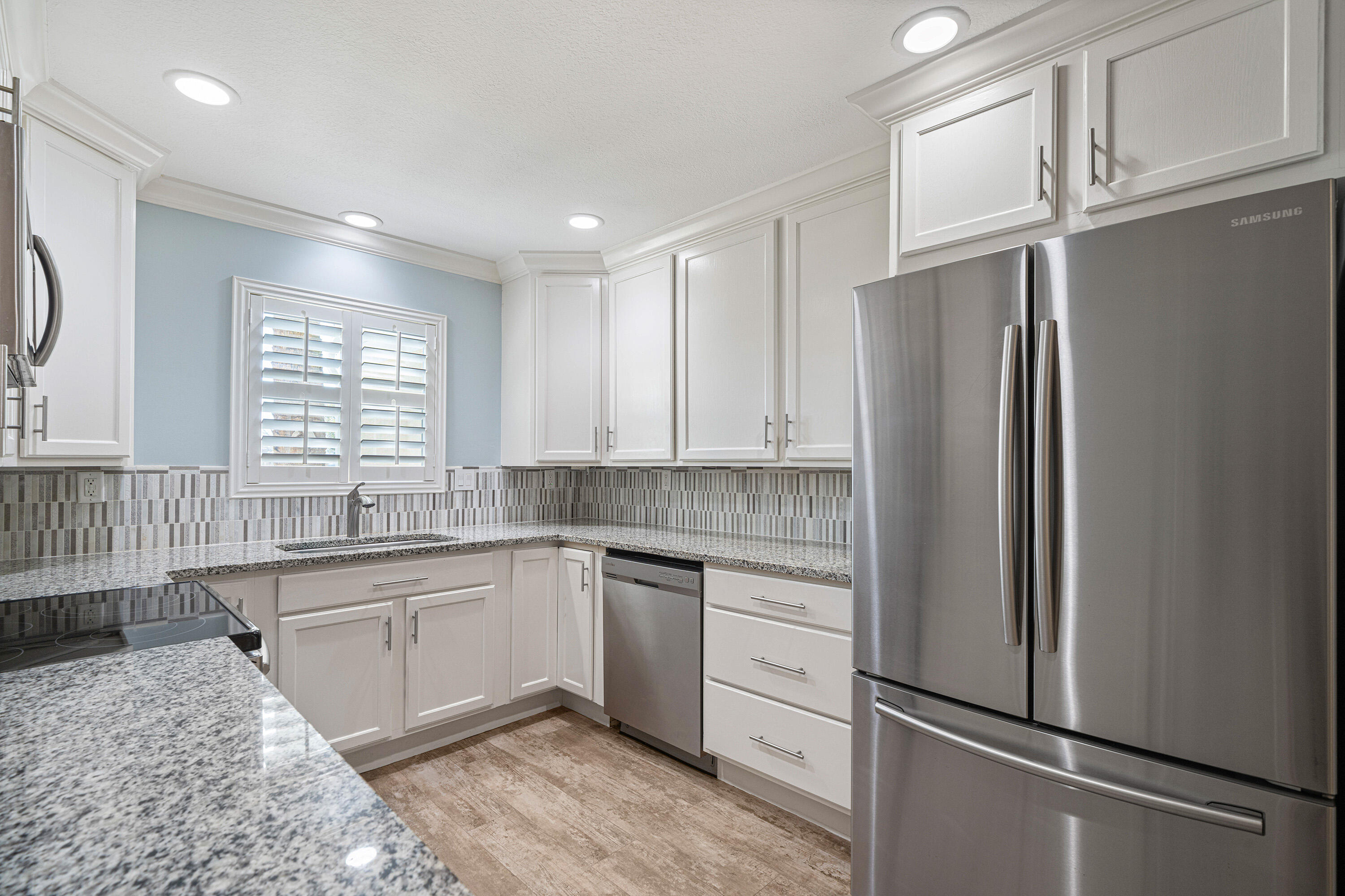 235 Pelican Place, Unit 3 Destin, FL 32541 - Photo 4 of 32 a kitchen with stainless steel appliances granite countertop a refrigerator sink and cabinets