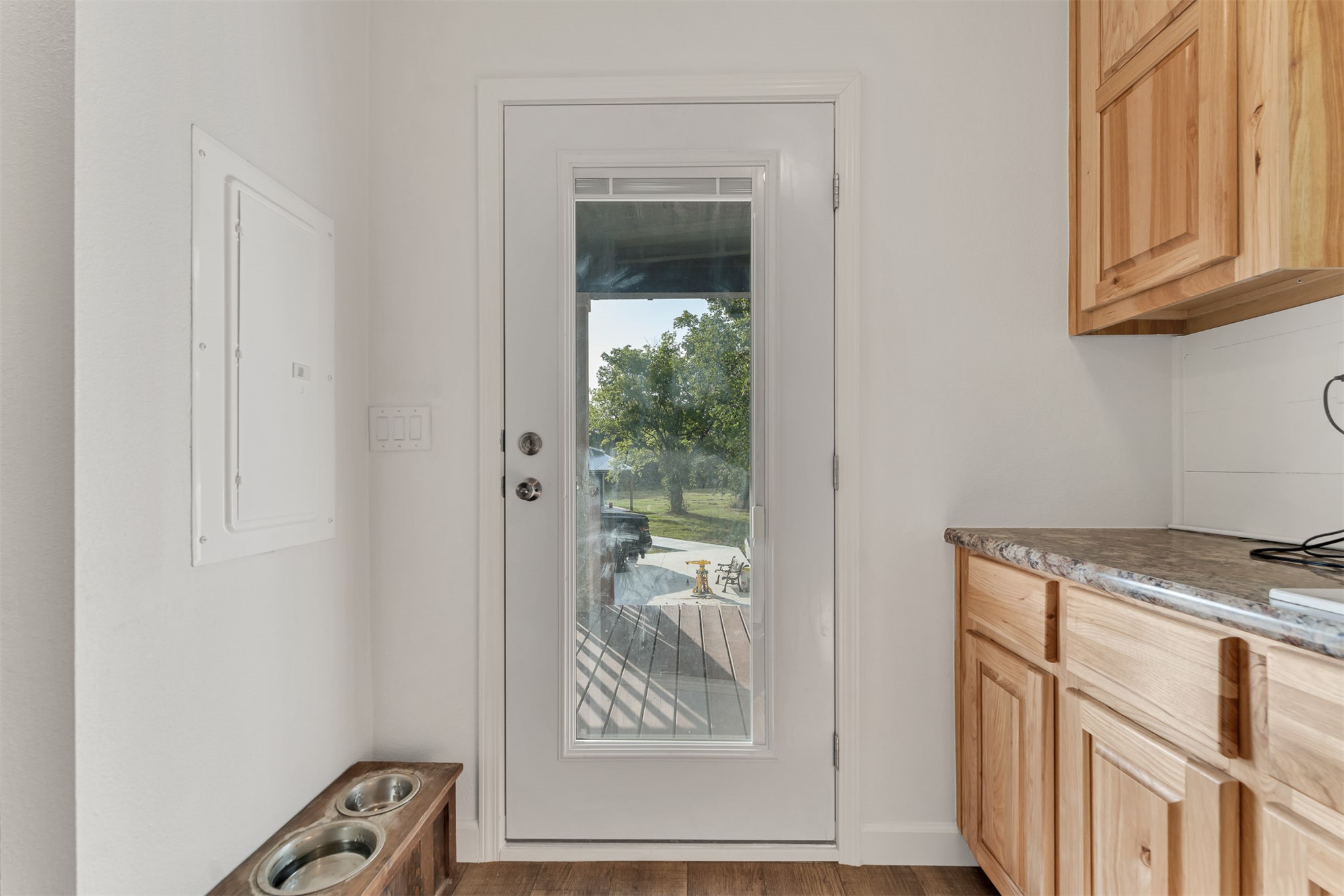 15291 East 400 Road Claremore, OK 74017 - Photo 54 of 96 Light wood-finish cabinetry, stone-finish countertop, white full-lite exterior door, and wood-finish flooring