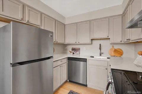 a kitchen with a sink a refrigerator and cabinets