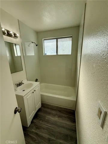 a bathroom with a tub sink and mirror